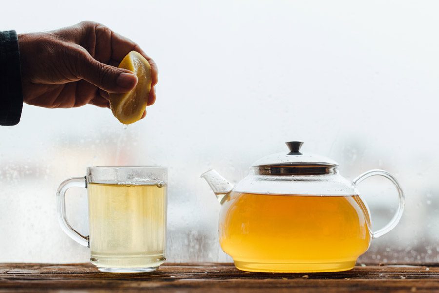 Hand-squeezing-lemon-into-cup-of-tea