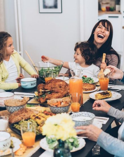 Family-eating-holiday-dinner-and-laughing